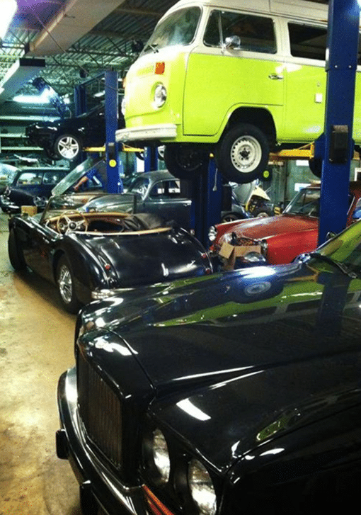 Various types of vehicles garaged at C's Autohaus auto shop. Concept image of auto repair and maintenance.