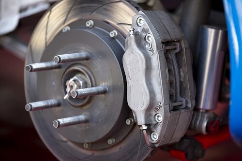 Brake Repair & Brake Inspection in Centerville, OH | C’s Autohaus. Closeup image of a brake caliper on a disc brakes with brake pads of a car.