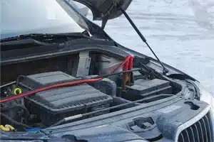 What Can Go Wrong with Your Car in Winter in Centerville, OH | C’s Autohaus. Image of a car battery being charged outside in winter.