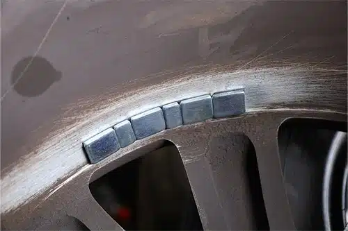 Tire Repair & Services | C's Autohaus in Centerville, OH. Closeup image of balancing lead mounted on a car wheel.