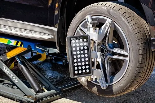When Should I Perform a Wheel Alignment? | C's Autohaus in Centerville, OH. Image of a mobile jack lifting a vehicle that is undergoing a wheel alignment.