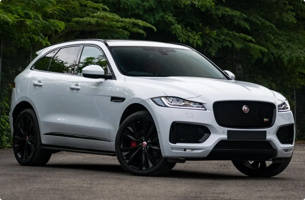 A white Jaguar vehicle parked outside.
