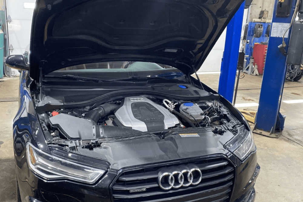audi repair, auto repair in Centerville, Ohio. C's Autohaus. A black Audi with its hood open inside a repair shop
