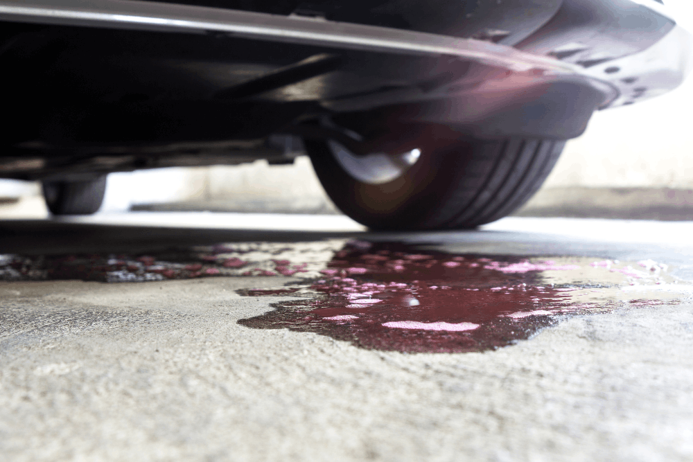 Car fluid leak, auto repair in Centerville, OH by C’s Autohaus. Image of fluid leaking beneath a vehicle, highlighting the need for prompt diagnostics, expert repair, and preventative maintenance to protect engine performance and prevent costly damage.