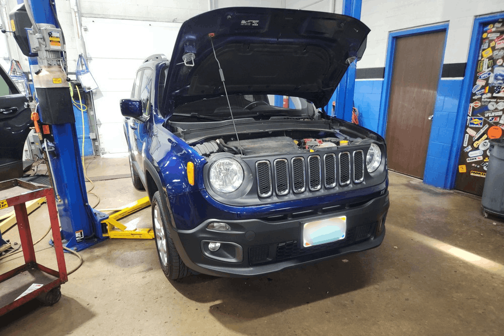 Car noises, auto repair in Centerville, OH at C’s Autohaus. Image of a Jeep SUV in an auto repair shop with the hood open, highlighting professional engine diagnostics and vehicle maintenance services.